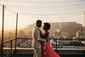 Black African couple dancing on a rooftop at sunset with musical notes in the air